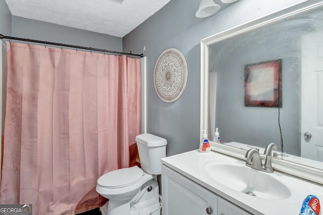 bathroom with vanity, a shower with curtain, toilet, and a textured ceiling