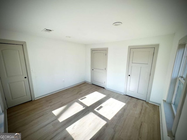 unfurnished bedroom with light wood-type flooring