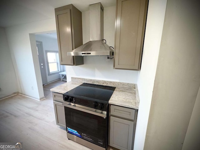 kitchen with stainless steel range with electric stovetop, gray cabinetry, light hardwood / wood-style floors, and wall chimney exhaust hood