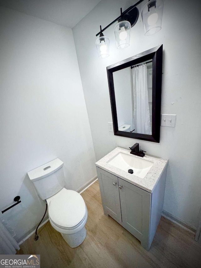 bathroom with vanity, hardwood / wood-style floors, and toilet