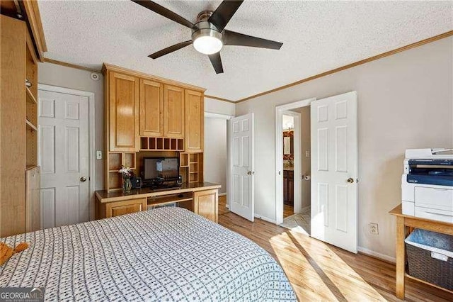 bedroom with ornamental molding, a textured ceiling, baseboards, and wood finished floors