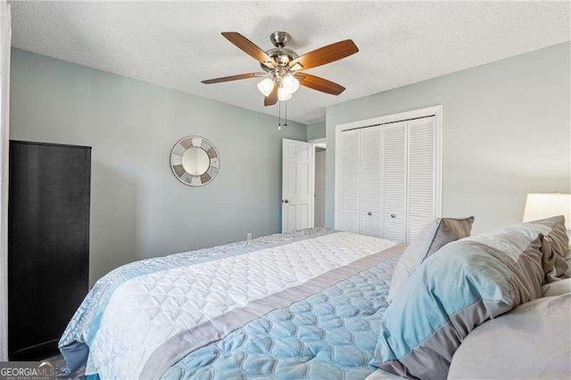 bedroom with a textured ceiling, a closet, and a ceiling fan