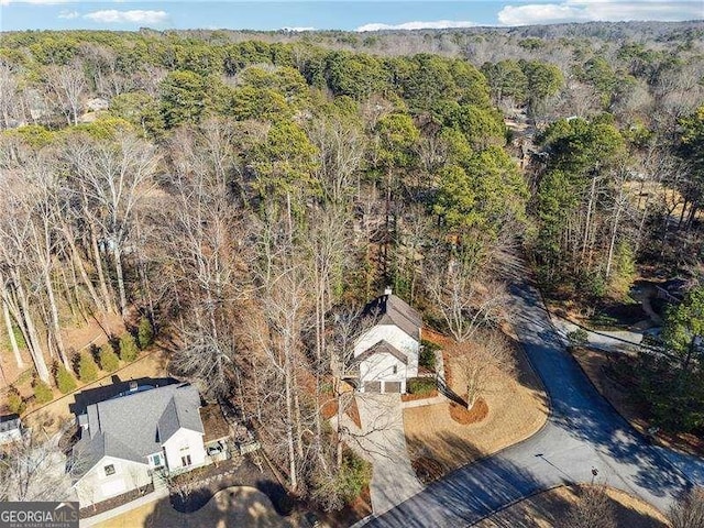 birds eye view of property featuring a forest view