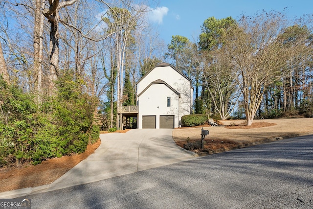 exterior space featuring driveway, an attached garage, and stucco siding