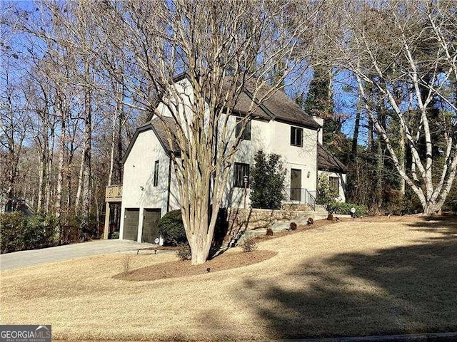 view of property exterior featuring a garage, driveway, and stucco siding