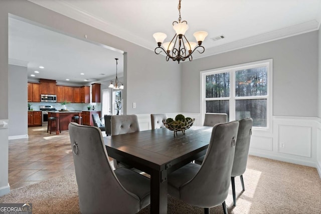 dining space with an inviting chandelier, ornamental molding, and light tile patterned floors