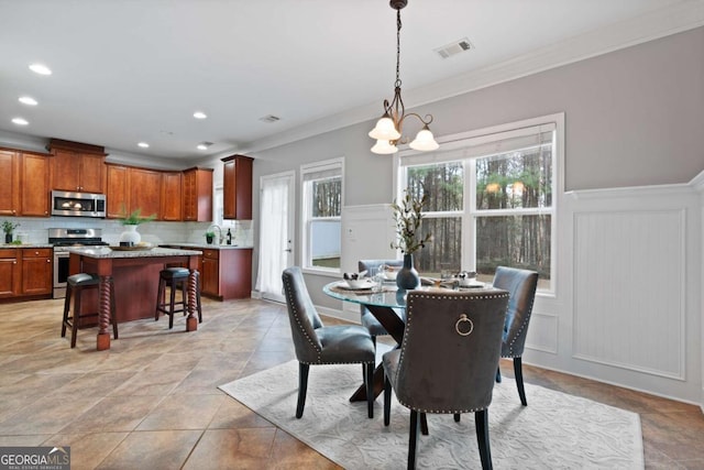 dining area with an inviting chandelier and ornamental molding