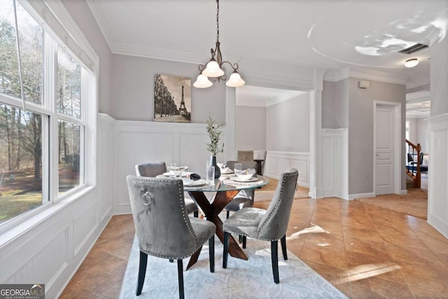 dining room with tile patterned flooring, ornamental molding, and a chandelier