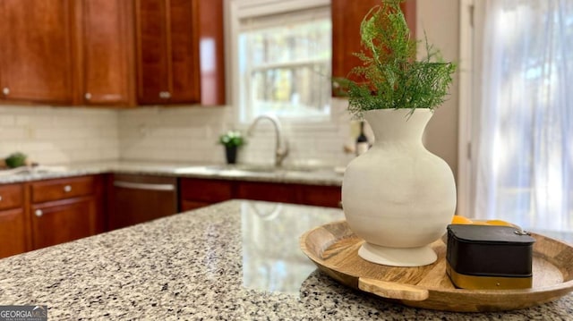 kitchen featuring light stone counters, sink, and tasteful backsplash