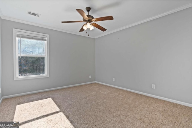 empty room featuring crown molding, carpet flooring, and ceiling fan