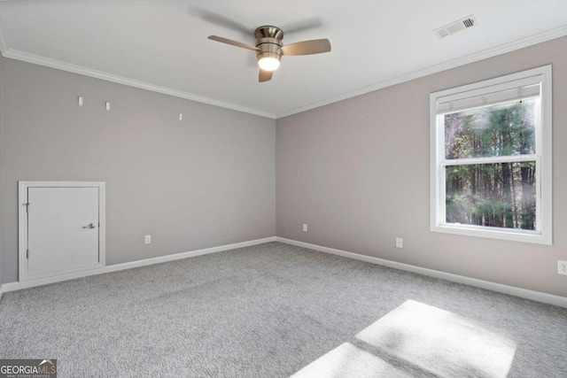 empty room with crown molding, ceiling fan, and carpet floors