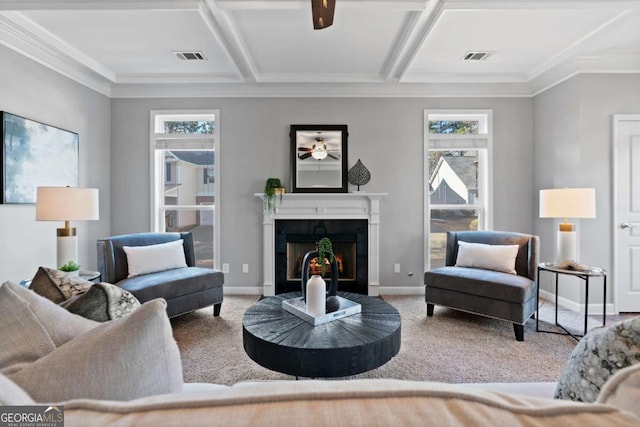 carpeted living room with coffered ceiling, a high end fireplace, ornamental molding, and ceiling fan