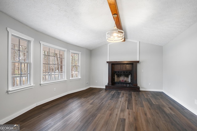 unfurnished living room featuring lofted ceiling with beams, a textured ceiling, a tiled fireplace, and wood finished floors