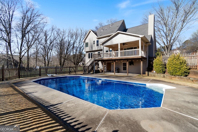 view of swimming pool with a patio, a diving board, and ceiling fan