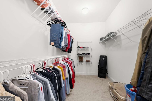 walk in closet featuring light colored carpet