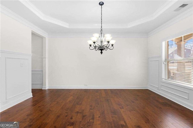 spare room with dark hardwood / wood-style flooring, a notable chandelier, ornamental molding, and a raised ceiling