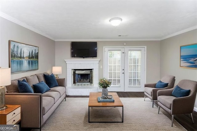 living room with french doors, ornamental molding, wood-type flooring, and a fireplace