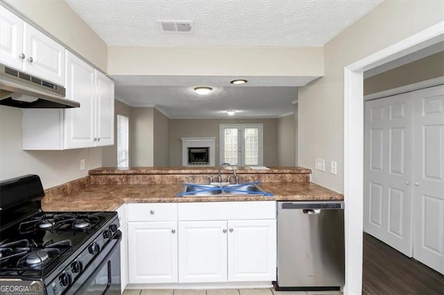 kitchen with sink, black range with gas stovetop, dishwasher, kitchen peninsula, and white cabinets