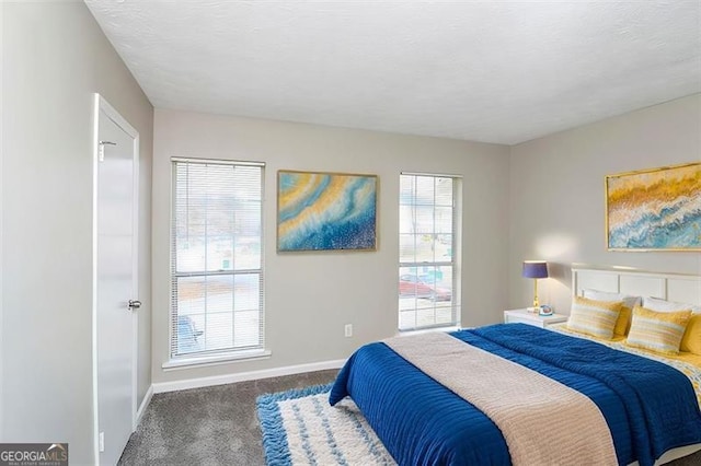 bedroom featuring dark carpet and a textured ceiling