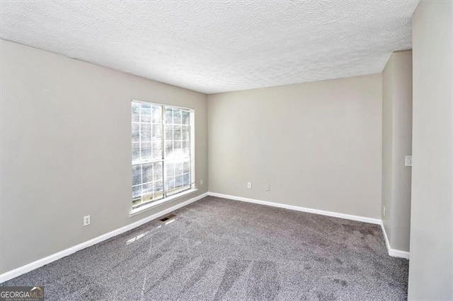 carpeted empty room with a textured ceiling