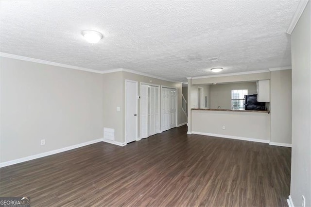 unfurnished living room with crown molding, dark wood-type flooring, and a textured ceiling