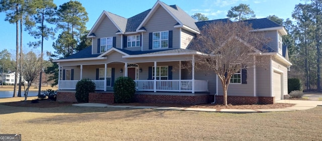 view of front facade with a garage, a front yard, and covered porch