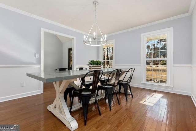 dining area featuring crown molding, plenty of natural light, and dark wood-type flooring