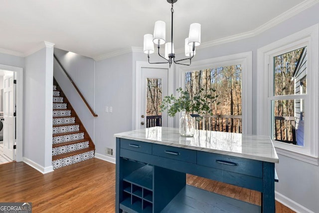 kitchen featuring crown molding, hardwood / wood-style floors, decorative light fixtures, and blue cabinetry