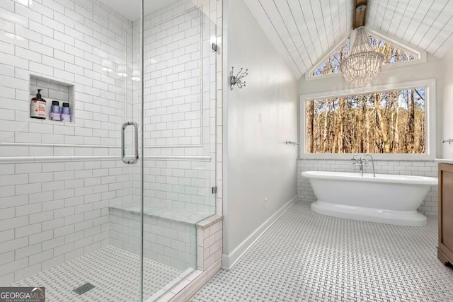 bathroom with an inviting chandelier, tile patterned floors, separate shower and tub, and vaulted ceiling