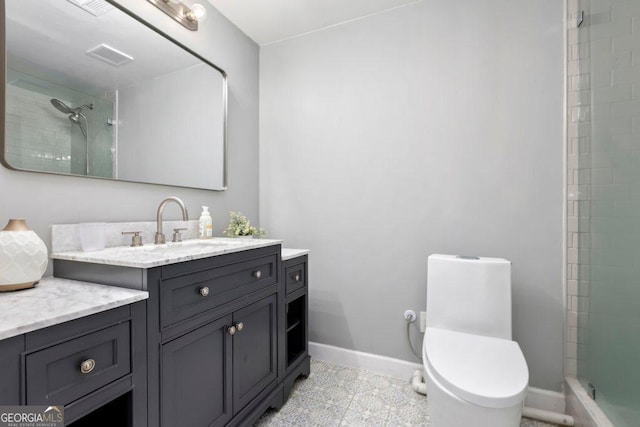 bathroom featuring vanity, tile patterned floors, toilet, and a tile shower