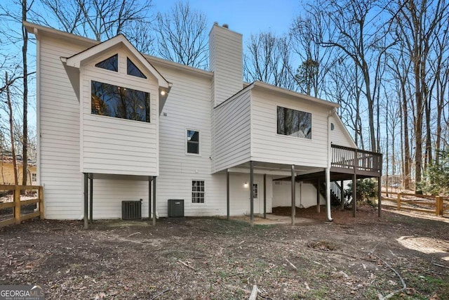 back of house with cooling unit and a deck