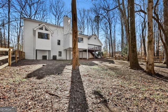 rear view of property with a wooden deck and central AC