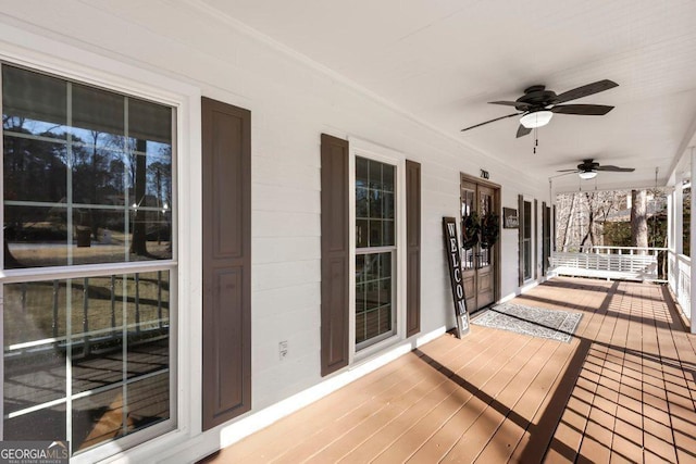 wooden deck featuring a porch and ceiling fan