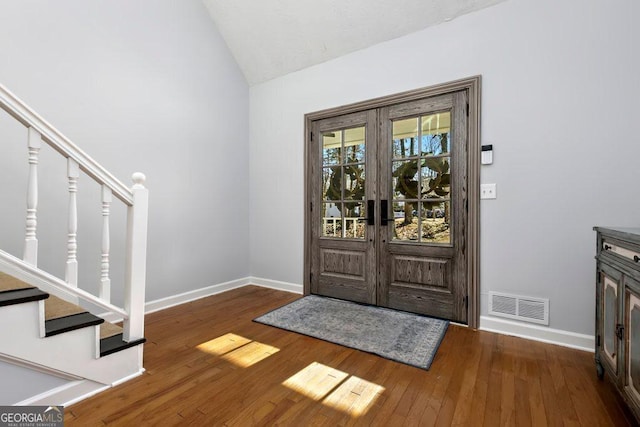 entryway with french doors, lofted ceiling, and dark hardwood / wood-style flooring