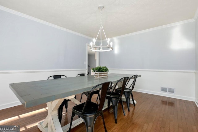 dining area with a notable chandelier, crown molding, and dark hardwood / wood-style floors