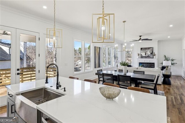 bar with stainless steel appliances, ornamental molding, white cabinets, and light stone counters