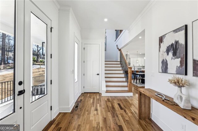 foyer featuring ornamental molding, hardwood / wood-style floors, and french doors