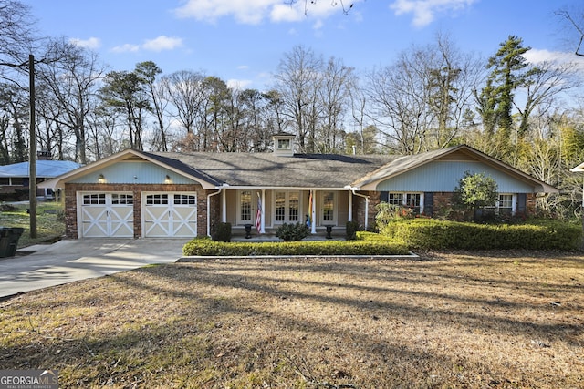 ranch-style home featuring a garage, a front yard, and covered porch