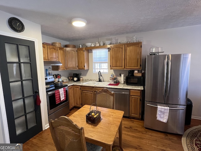 kitchen featuring sink, dark wood-type flooring, a textured ceiling, and appliances with stainless steel finishes