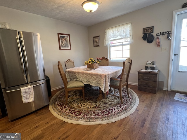 dining area with hardwood / wood-style floors and a textured ceiling