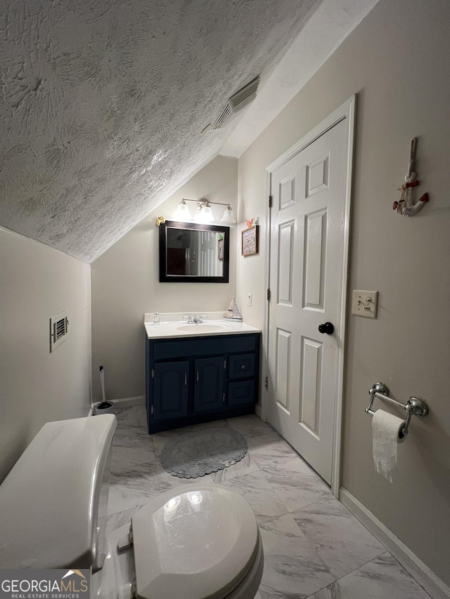 bathroom featuring vanity, lofted ceiling, and a textured ceiling