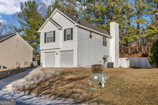 view of side of home featuring a garage and a lawn