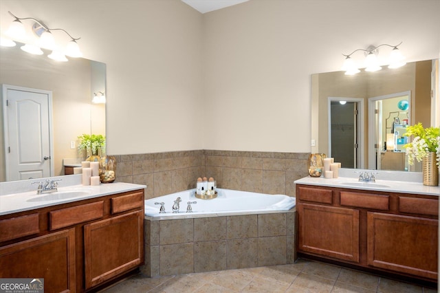 bathroom featuring vanity, tile patterned flooring, and tiled bath