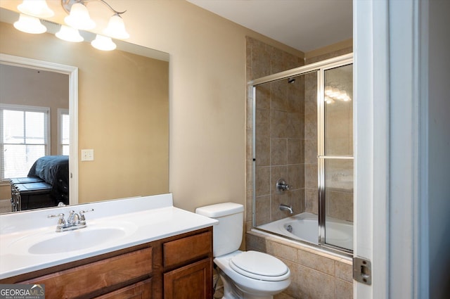 full bathroom with vanity, bath / shower combo with glass door, an inviting chandelier, and toilet