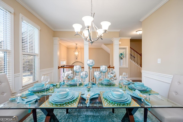 dining space with an inviting chandelier, ornamental molding, and ornate columns