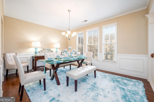 dining room with crown molding, dark hardwood / wood-style floors, and a chandelier