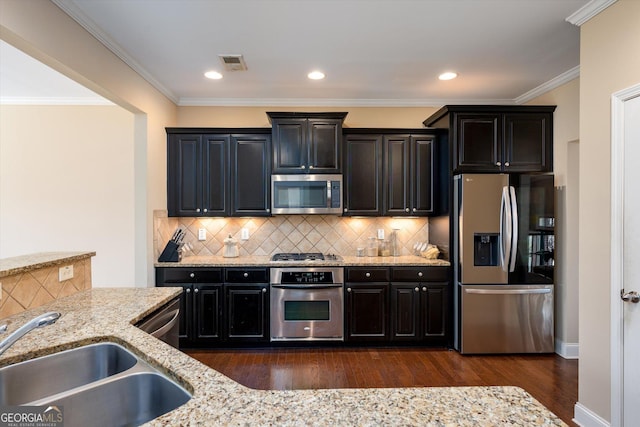 kitchen with light stone counters, appliances with stainless steel finishes, dark wood-type flooring, and decorative backsplash