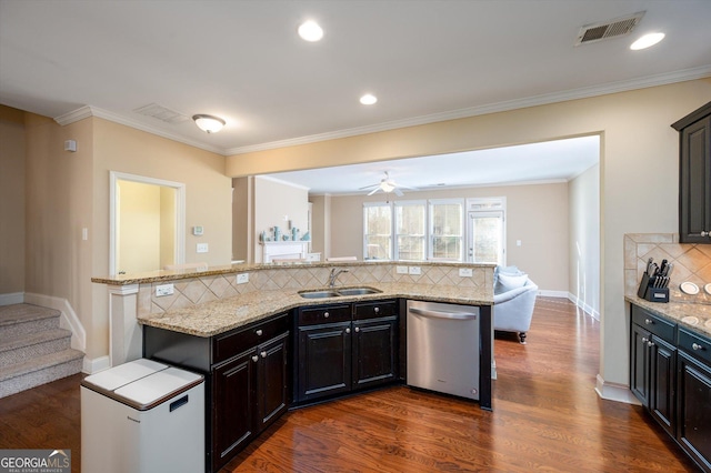 kitchen featuring sink, dark wood-type flooring, dishwasher, backsplash, and light stone counters