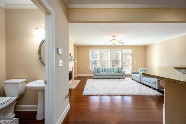 unfurnished living room featuring crown molding, ceiling fan, and dark hardwood / wood-style flooring