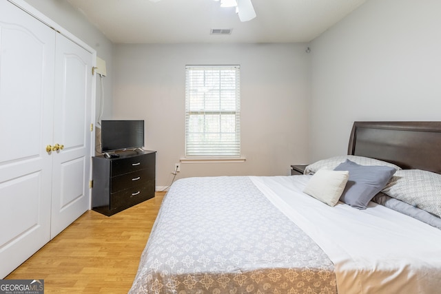 bedroom with a closet, visible vents, light wood-style flooring, and ceiling fan